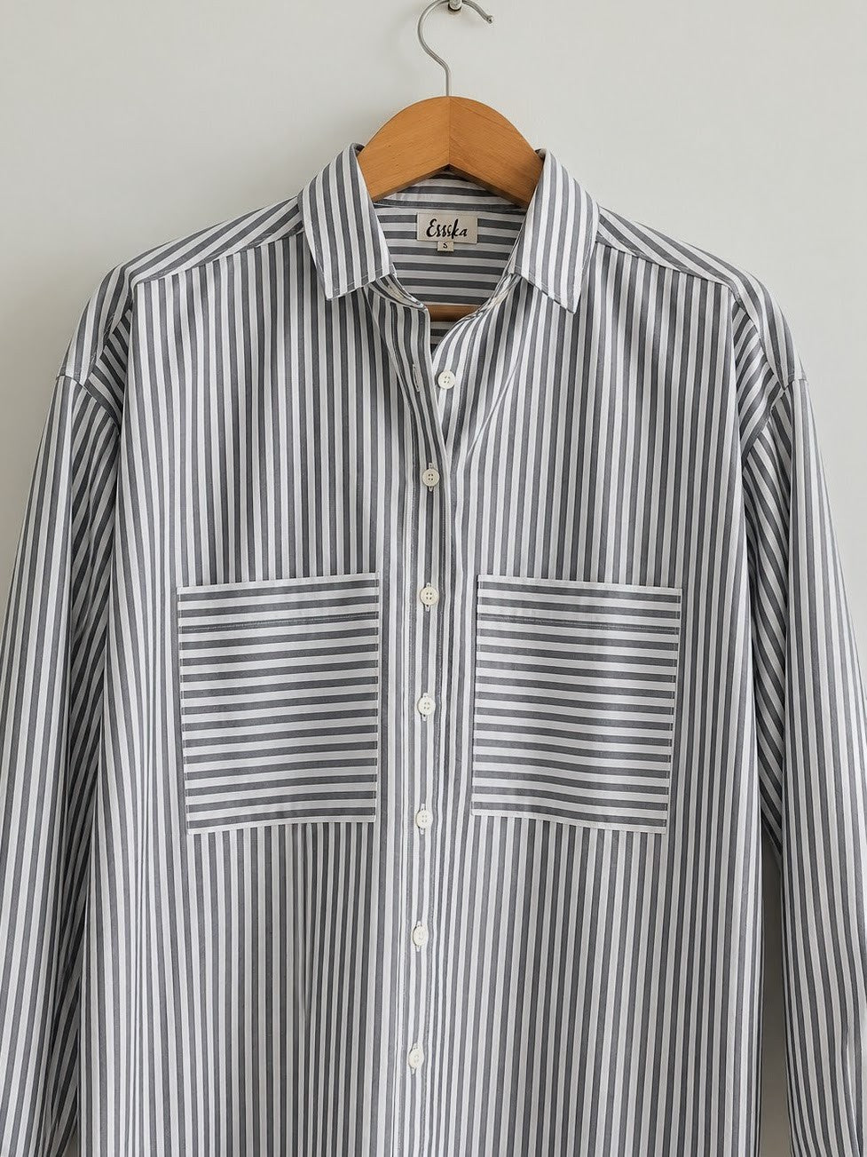 Women's oversized shirt in black and white stripes with full sleeves and  wider cuffs, features two pockets in the front  - closeup image